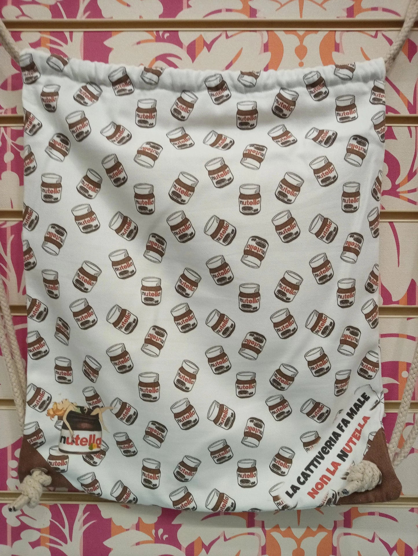 Zaino a sacca street style con motivo Nutella, cordini e scritta, sfondo colorato urban.