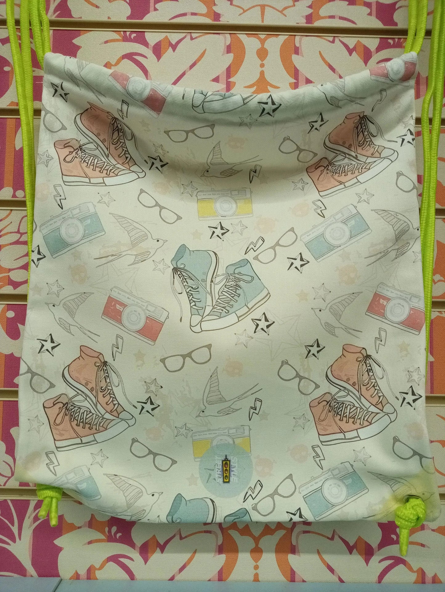 Zaino a sacca street style con disegni di sneakers, fotocamere e occhiali, fondo bianco, stile urban