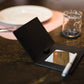 K0008AB | Porta Conto in Vera Pelle pieno fiore, grana dollaro. Mini slot interne e asola porta penna. Colore Nero. Dimensioni: cm 12 x 16 x 1.  Confezione: Sacchetto Tnt-0